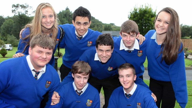 Eine Gruppe von Schülerinnen und Schülern der Royal & Prior Comprehensive School steht im Freien vor einem Wald.