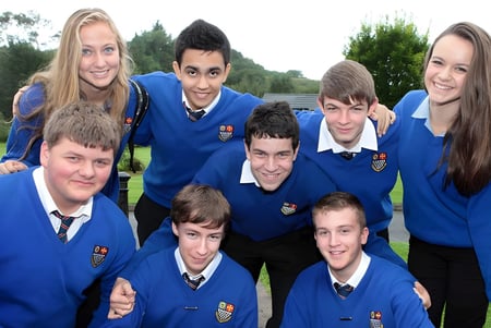 Eine Gruppe von Schülerinnen und Schülern der Royal & Prior Comprehensive School posiert draußen auf einer Wiese mit Bäumen im Hintergrund.