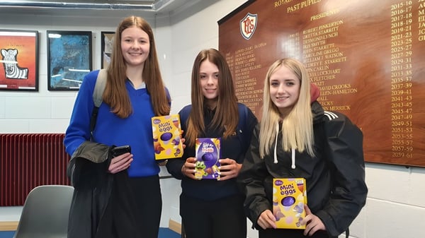 Drei Schülerinnen stehen zusammen im Flur der Royal & Prior Comprehensive School und halten Bücher in der Hand.