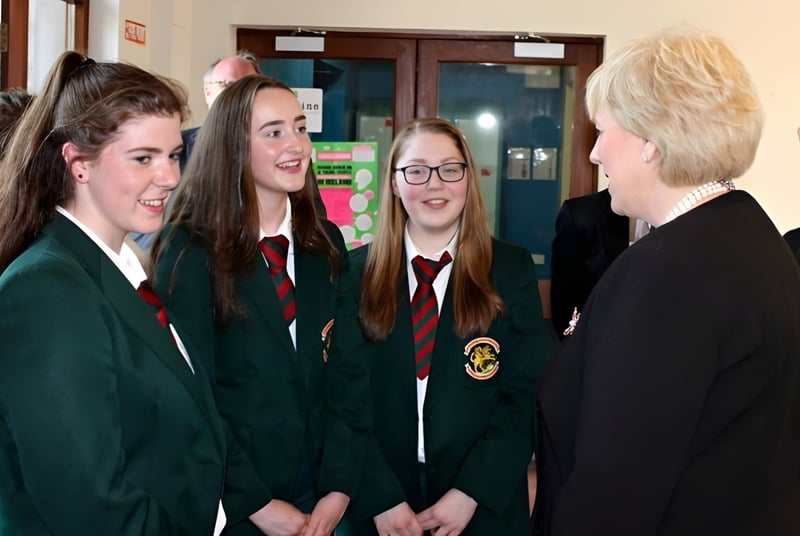 Schüler der Royal School Cavan unterhalten sich im Schulflur in ihren Schuluniformen mit grünen und schwarzen Roben.
