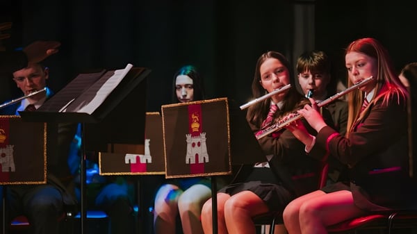 Eine Gruppe von Musikerinnen und Musikern der Royal School Dungannon spielt gemeinsam verschiedene Instrumente auf der Bühne.