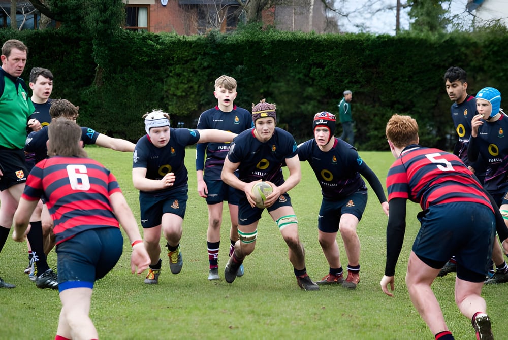 Eine Gruppe von Rugby spielenden Schülerinnen und Schülern auf dem Spielfeld der Royal School.
