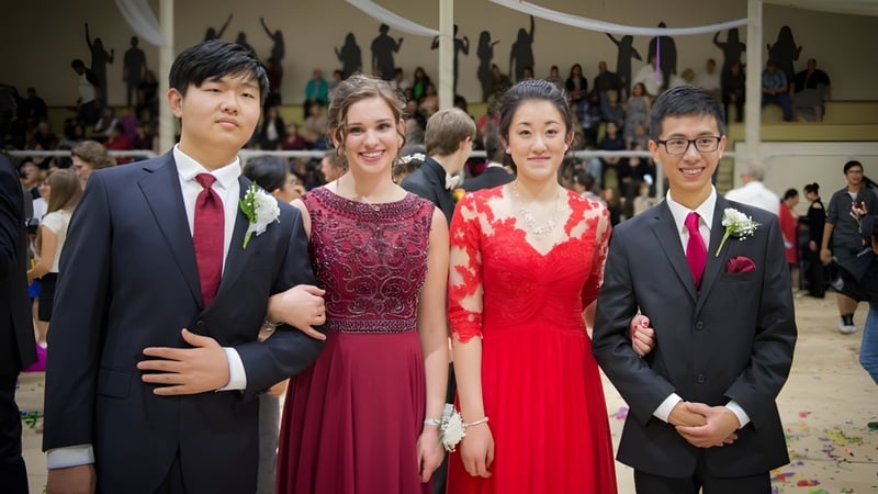 Vier Schülerinnen und Schüler der Royal Vale High School stehen zusammen bei einer formellen Veranstaltung in einem Auditorium.