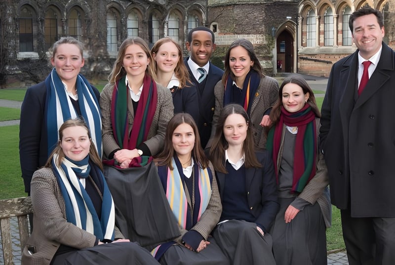 Eine Gruppe Schüler der Rugby School posiert vor einem historischen Gebäude mit gotischer Architektur.