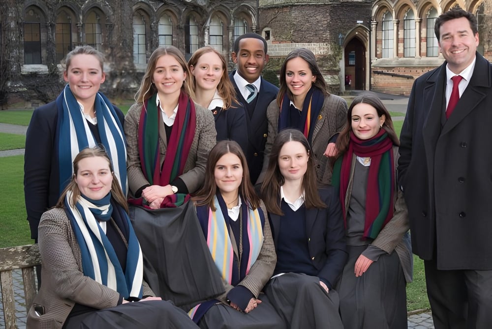 Eine Gruppe Schüler der Rugby School posiert vor einem historischen Gebäude mit gotischer Architektur.