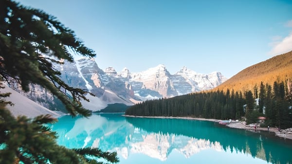 Ein türkisfarbener See mit schneebedeckten Bergen und dichten Wäldern in der Nähe der Russell High School.