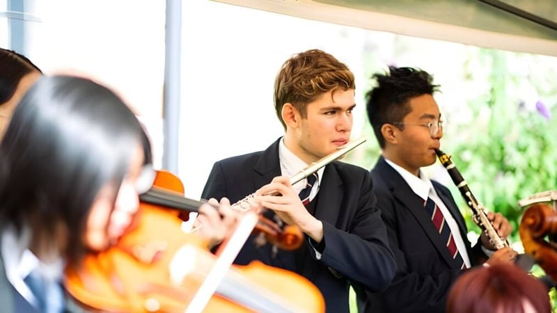 Zwei Schüler in formeller Kleidung stehen in einem Innenbereich auf dem Campus der Ruthin School.