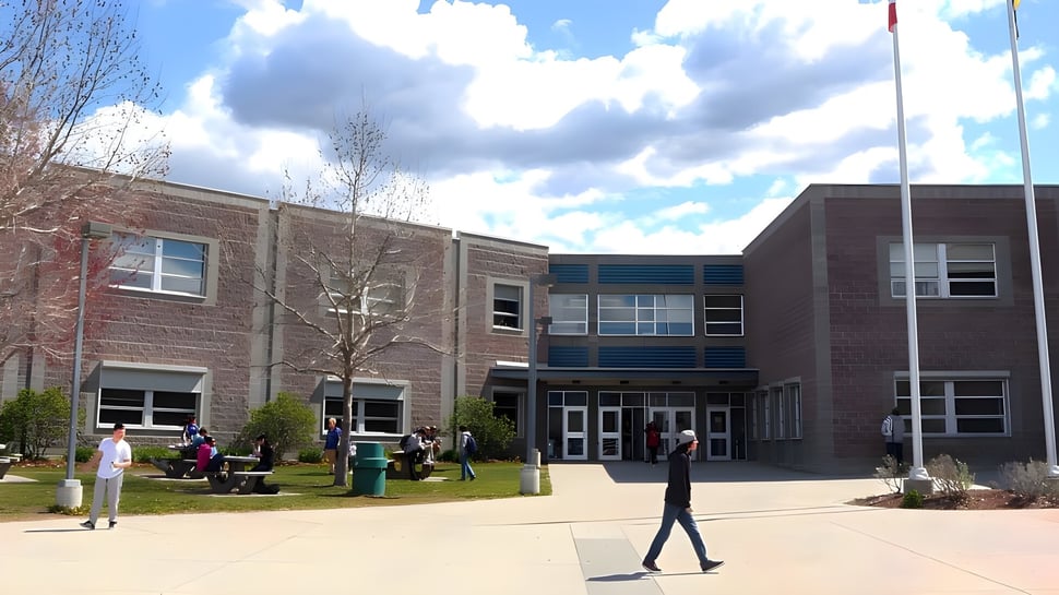 Das Backsteingebäude mit großem Eingang und Hoffläche auf dem Campus der Rutland Senior Secondary School bei bewölktem Himmel.