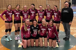 Eine Gruppe von Volleyballspielerinnen der Rutland Senior Secondary School posiert zusammen mit ihrem Trainer in der Sporthalle.