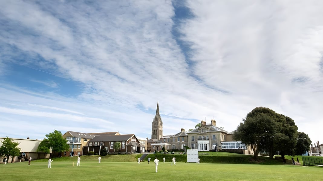 Eine grüne Wiese mit Blick auf historische Gebäude und einen Kirchturm nahe der Ryde School.