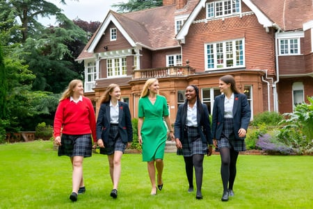 Vier junge Frauen stehen vor dem historischen Backsteingebäude auf dem Gelände der Rye St. Antony School.