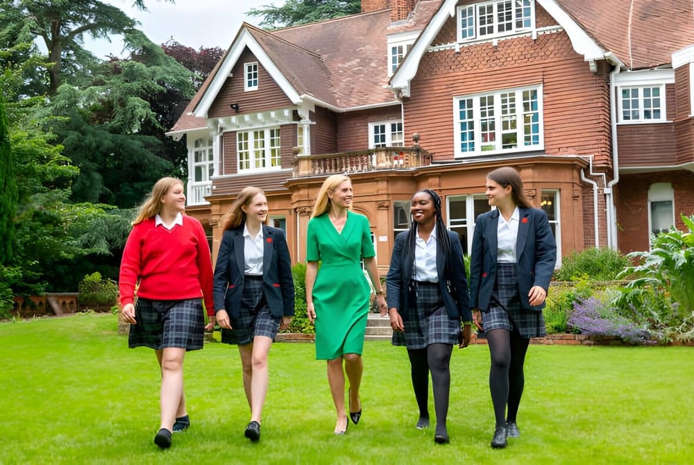 Vier junge Frauen stehen vor dem historischen Backsteingebäude auf dem Gelände der Rye St. Antony School.