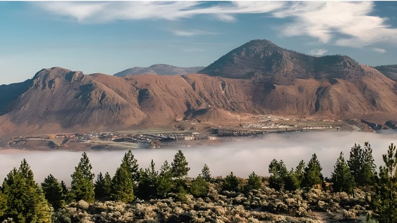 Blick auf schneebedeckte Berge und ein bewaldetes Tal in der Nähe der Sa-Hali Secondary School.