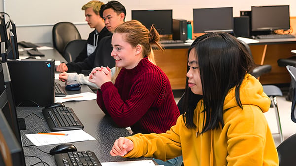 Eine Gruppe Schülerinnen und Schüler der Sa-Hali Secondary School sitzt im Computerraum und arbeitet an Computern.
