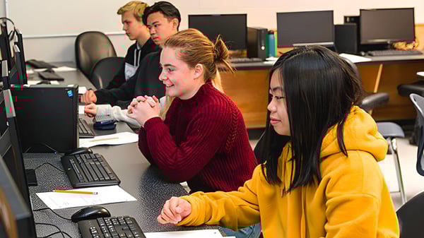Eine Gruppe Schülerinnen und Schüler der Sa-Hali Secondary School sitzt im Computerraum und arbeitet an Computern.