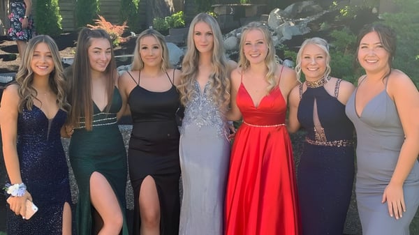 Eine Gruppe von sechs Schülerinnen der Sa-Hali Secondary School posiert im Freien vor einem Holzbau und grüner Vegetation.