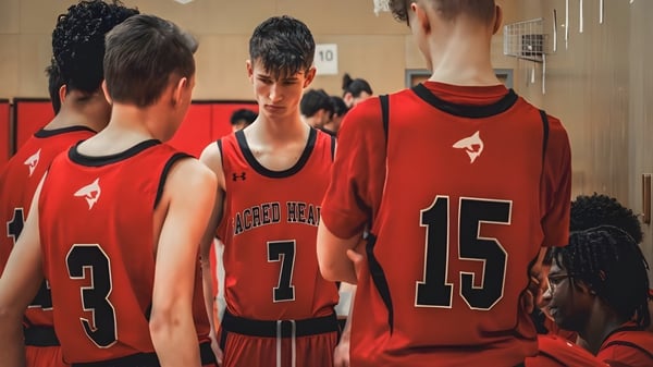Schüler der Sacred Heart School of Halifax stehen in roten Trikots gemeinsam in der Umkleidekabine der Basketballmannschaft.