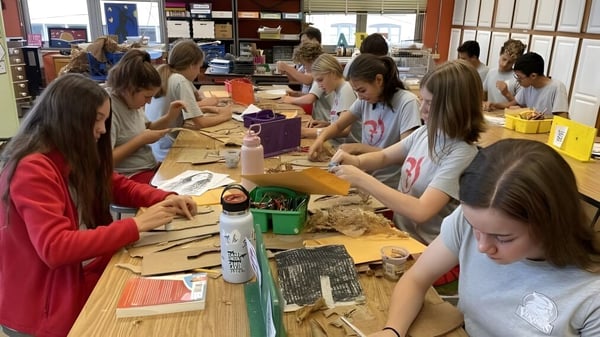 Schülerinnen und Schüler der Sacred Heart Secondary School in Tullamore arbeiten an Bastelprojekten an einem Tisch.