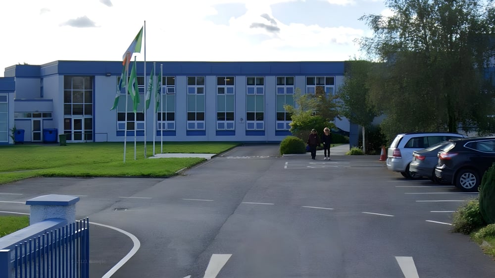 Das moderne mehrstöckige Gebäude der Sacred Heart Secondary School in Tullamore ist von einer Grünfläche und einem gepflasterten Weg zur Eingangstür umgeben.