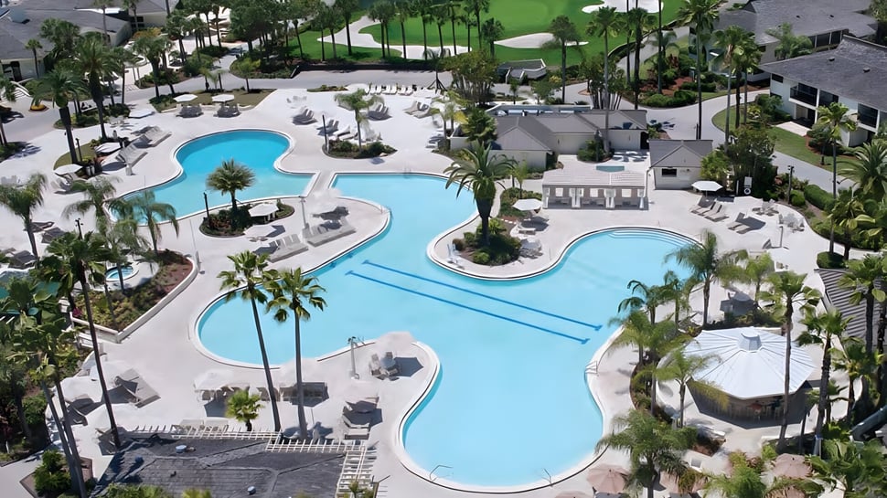 Der große Poolbereich mit Palmen und Gebäuden auf dem Gelände der Saddlebrook Preparatory School.