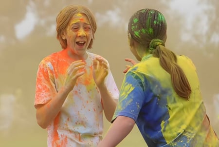 Schüler der Safety Bay Senior High School nehmen an einem bunten Farbfestival im Freien teil.
