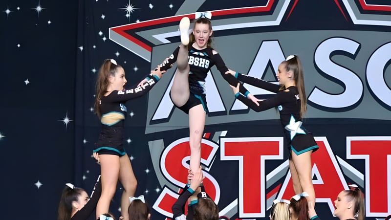 Schülerinnen der Safety Bay Senior High School führen eine Tanzperformance auf der Bühne mit dem großen ASC STAT Logo im Hintergrund auf.