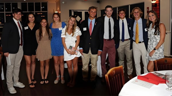 Eine Gruppe von Personen befindet sich bei einer Veranstaltung der Saint Andrews School in einem formellen Raum mit Sofas.