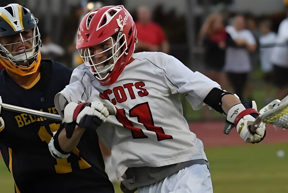 Zwei Lacrosse-Spieler der Saint Andrews School kämpfen auf dem Sportfeld in einem Spiel gegeneinander.