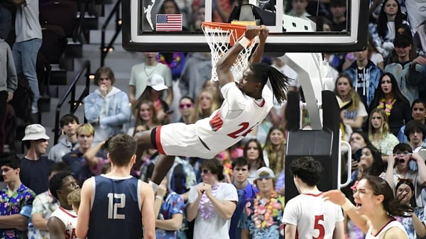 Ein Basketballspieler der Saint Bernard School springt zum Dunk während eines Spiels vor Zuschauern.