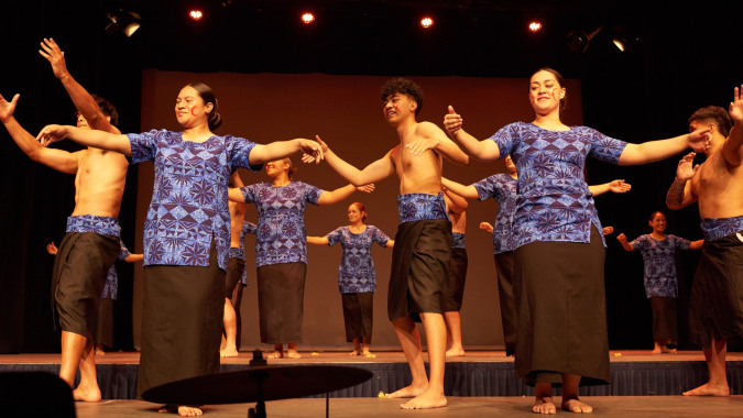 Schüler des Saint Kentigern College stehen in bunten Kostümen auf der Bühne während einer Theateraufführung.