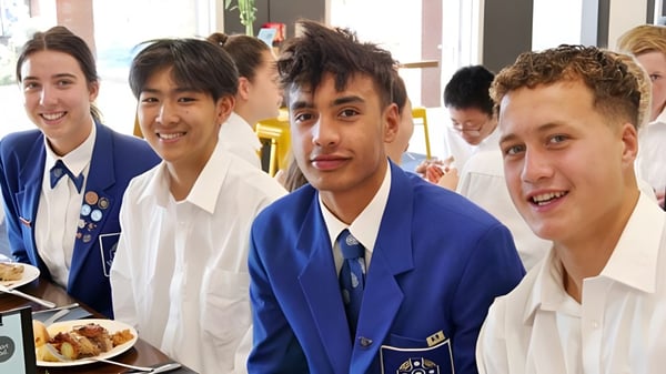 Schüler des Saint Kentigern College sitzen gemeinsam an einem Tisch und essen in der Mensa der Schule.