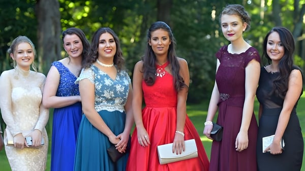 Fünf Schülerinnen der Salerno Secondary School stehen in eleganten Kleidern gemeinsam im grünen Außenbereich.