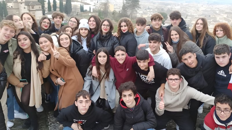 Eine große Gruppe von Schülerinnen und Schülern der Salesianas steht draußen in der Stadt und posiert für ein Gruppenfoto.