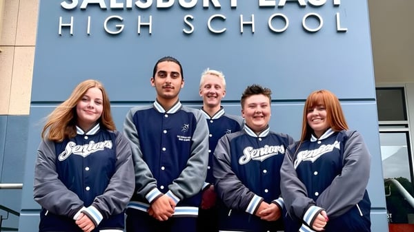 Fünf Schüler der Salisbury East High School in Schuljacken stehen vor dem Schulgebäude.