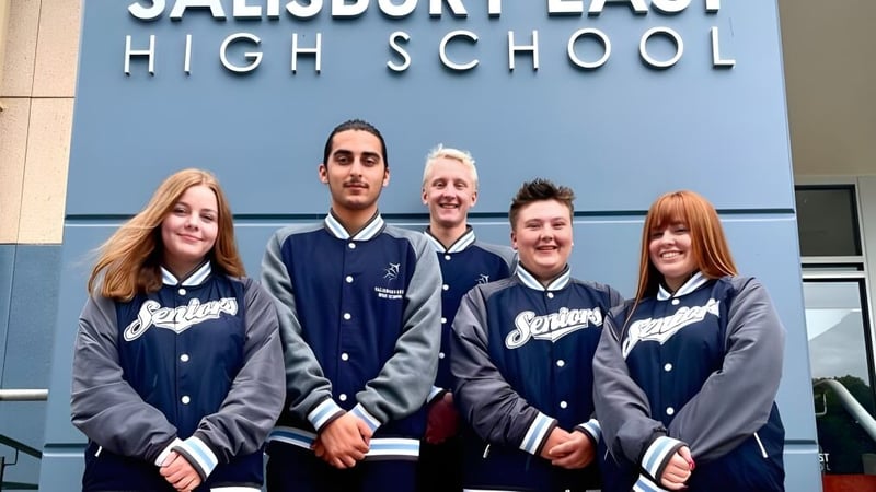 Fünf Schüler der Salisbury East High School in Schuljacken stehen vor dem Schulgebäude.