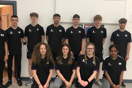 Eine Gruppe von Schülern in schwarzen Shirts steht gemeinsam in einem Klassenraum des Salisbury Sixth Form College.