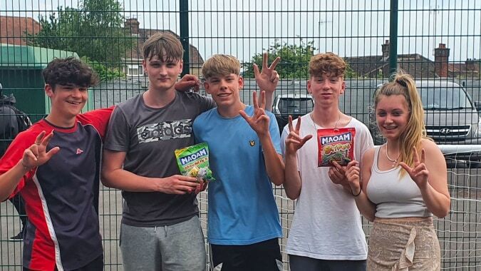 Eine Gruppe von Schülerinnen und Schülern steht vor einem eingezäunten Bereich auf dem Campus des Salisbury Sixth Form College.