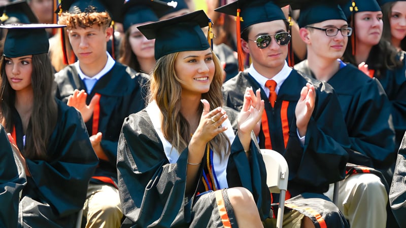 Absolventinnen und Absolventen der Samuel Robertson Secondary School stehen gemeinsam im Abschlussgewand und lächeln in die Kamera.