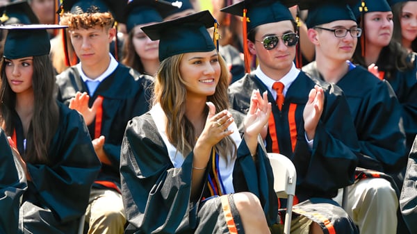 Absolventinnen und Absolventen der Samuel Robertson Secondary School stehen gemeinsam im Abschlussgewand und lächeln in die Kamera.