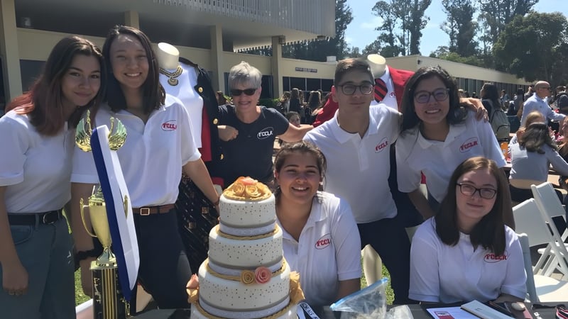 Schüler der San Luis Obispo High School feiern gemeinsam im Freien mit einem großen Kuchen.