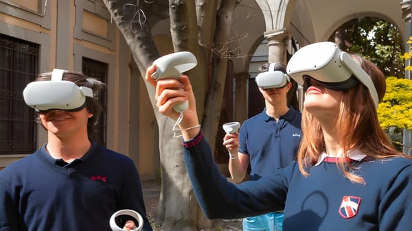 Schüler der International School San Patricio Toledo tragen Virtual-Reality-Headsets in einem Außenbereich mit Bäumen und Gebäuden.