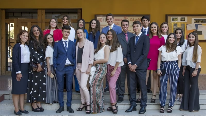 Eine Gruppe von Schülerinnen und Schülern steht in einem Holzraum mit gerahmten Bildern an der Wand auf dem Campus der San Vicente de Paul Schule.