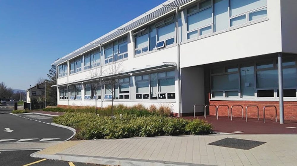 Das moderne mehrstöckige Gebäude des Sancta Maria College (Ballyroan) mit großen Fenstern und einem gepflasterten Weg im Vordergrund.