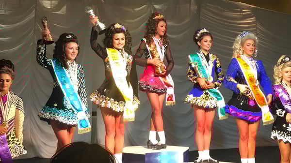 Eine Gruppe junger Frauen in bunten Kostümen steht auf der Bühne des Sancta Maria College Ballyroan.