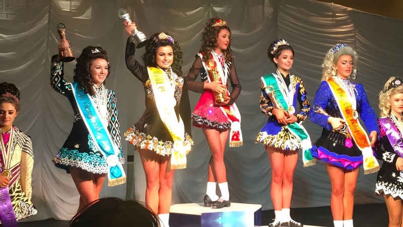 Eine Gruppe junger Frauen in bunten Kostümen steht auf der Bühne des Sancta Maria College Ballyroan.