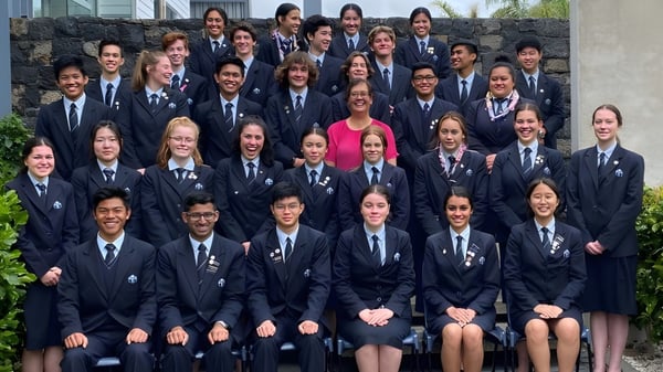 Eine große Gruppe Schüler in Schuluniformen versammelt sich im Außenbereich auf dem Campus des Sancta Maria College.