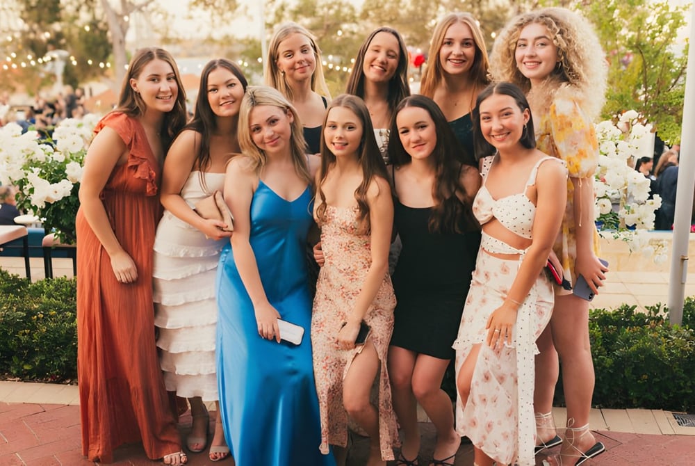 Eine Gruppe Schülerinnen des Sancta Maria College posiert draußen vor Bäumen und einem gepflasterten Weg.