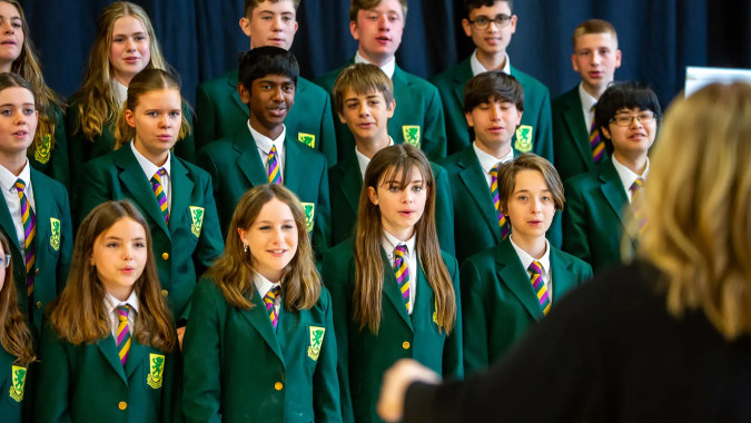 Eine Gruppe von Schülerinnen und Schülern der Sandford Park School Dublin steht vor einem dunkelblauen Vorhang.