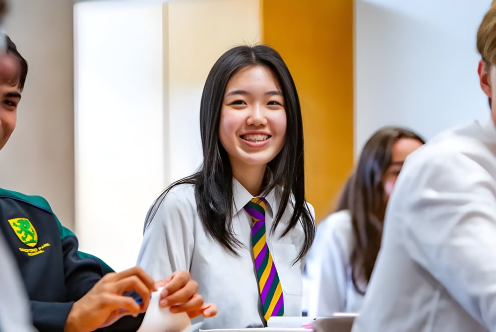 Eine Gruppe Schüler der Sandford Park School steht zusammen, im Fokus eine lächelnde junge Frau.