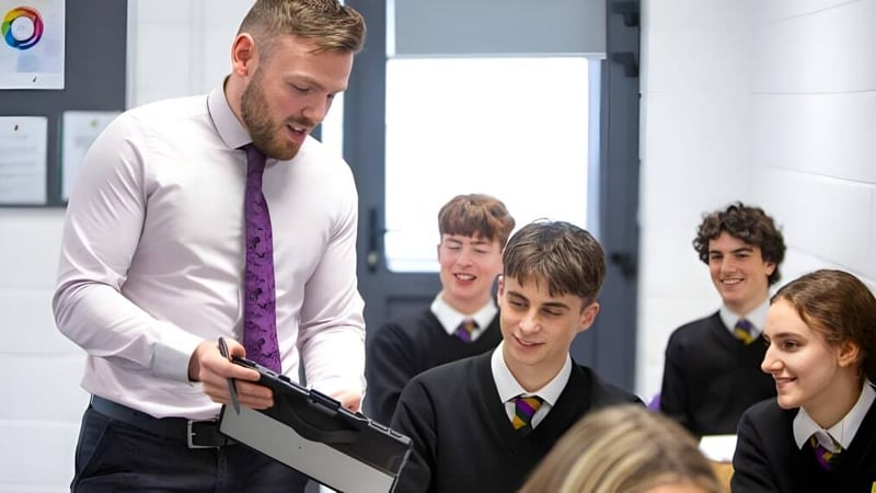 Ein Lehrer erklärt einer Gruppe Schüler im Klassenzimmer der Sandford Park School eine Unterrichtsstunde.